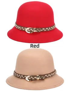 Dettaglio di cappelli cloche in lana rossa e kaki con fasce intrecciate e fibbie dorate