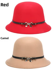 Close-up of red and camel wool felt fedora hats featuring elegant golden bow metal details