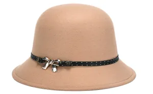 Detail of camel wool cloche hat featuring a black band and gold bow metal buckle