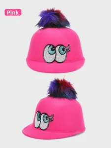 Detail of fuchsia wool hat featuring sequined cartoon eyes and colorful faux fur pompom