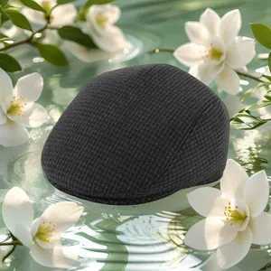 Detailed close-up of charcoal grey winter flat cap with thick waffle knit texture