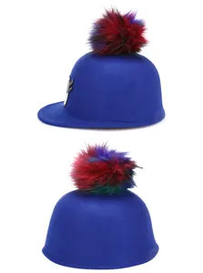 Close-up of royal blue wool felt hat featuring colorful faux fur pom-poms and sequin embroidery