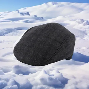 Close-up of winter wool flat cap for men with thick material on snowy background
