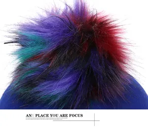 Detail of colorful faux fur pom-pom on top of a royal blue wool fashion hat