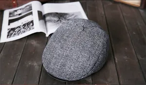Detailweergave van heren newsboy pet met zwart-wit visgraatpatroon voor de winter
