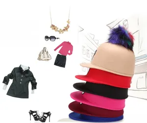 Flat lay of colorful wool felt hats with fluffy faux fur pom poms and fashion accessories