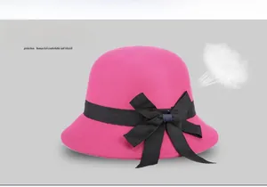 Detail of rose red wool cloche hat featuring a black grosgrain ribbon bow decoration