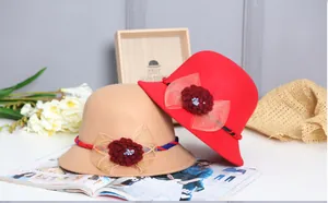 Detail of wool felt cloche hats featuring decorative crochet flowers and lace mesh bows