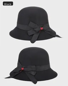 Detail of black wool felt bucket hat featuring grosgrain ribbon and bow with red accent