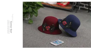 Détail de chapeaux cloches en laine bordeaux et marine avec nœud résille et fleurs
