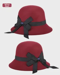 Detail view of a wine red wool felt cloche hat for women with a black bow ribbon
