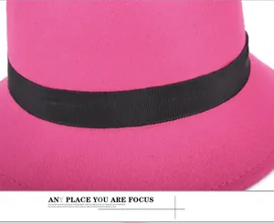 Detailed view of magenta wool felt hat featuring a black ribbed ribbon and neat stitching