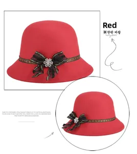 Detalle de sombrero cloche de fieltro rojo con lazo de encaje y flor de cristal