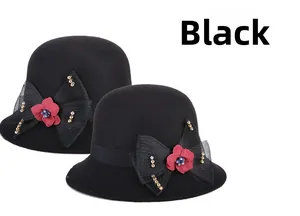 Détail du chapeau cloche en laine noire avec nœud en résille, fleur rouge et perles