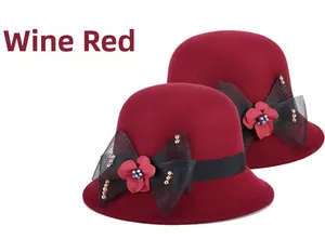 Détail d'un chapeau cloche en laine bordeaux avec nœud en maille noire et perles dorées
