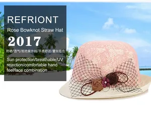 Détail d'un chapeau de soleil en dentelle rose avec roses en tissu et voile en résille