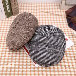 Detail of wool blend newsboy caps in brown tweed and black and white houndstooth patterns
