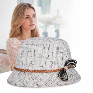 Dettaglio dell'elegante cappello in lino grigio con cinturino in pelle e fiocco di perle
