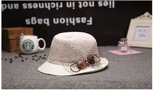 Détail d'un chapeau de soleil élégant en dentelle avec roses en tissu et résille