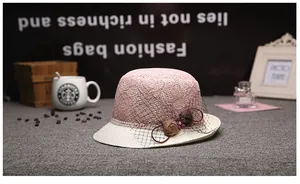 Détail d'un chapeau d'été élégant en dentelle rose avec fleurs en tissu et voile