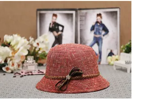 Dettaglio cappello cloche in lino rosso con fiocco nero di paillettes e cristallo