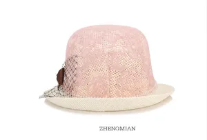 Détail d'un chapeau de soleil en dentelle rose avec perles et voile élégant