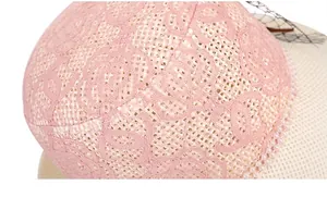 Détail d'un chapeau de paille avec dentelle rose, perles blanches et texture de voile noir