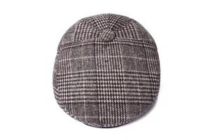 Bovenaanzicht van retro wollen flat cap met pied-de-poule patroon en warme winterstof
