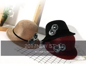 Detail view of winter cloche hats with velvet bands, faux fur poms, and rhinestone accents