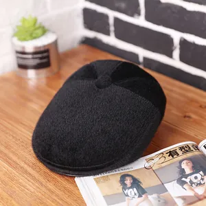 Klassieke zwarte wollen platte pet voor heren met warme pluche textuur op tafel