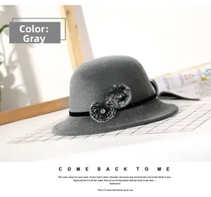 Close-up of grey wool bucket hat featuring decorative pom-poms and rhinestone detailing