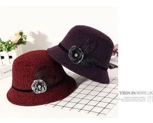 Detail of winter cloche hat with floral embroidery, pom pom, and rhinestone accents