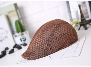 Detail view of brown breathable mesh flat cap for men on a stylish display background