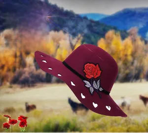 Detailed view of wine red wool hat with rose embroidery and white heart pattern