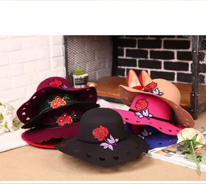 Detail view of wool felt wide brim hats with rose embroidery and heart-shaped cutouts