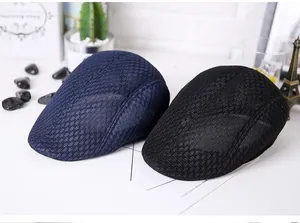 Close-up of navy blue and black mesh flat caps with breathable diamond knit texture
