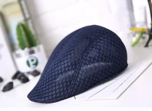Detail of navy blue mesh ivy cap with breathable lace weave on a white table