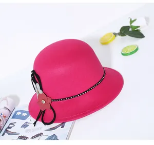 Detail of rose red wool felt cloche hat with floral rhinestone and bow accent