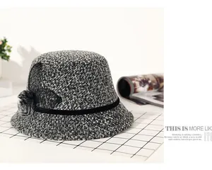 Close-up of black and white tweed bucket hat with ribbon, mesh bow and soft fur pompom