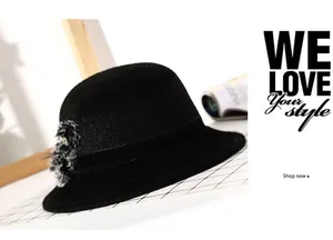 Detail of black cloche hat with rhinestone-embellished pom-pom and wool texture