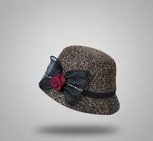 Detail of wool fedora with mesh bow, rhinestones, and wine red fabric rose flower