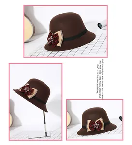 Detailweergaven van een donkerbruine wollen cloche hoed met strass bloem en strikaccent