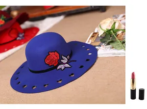 Detail view of navy wool fedora featuring red rose embroidery and heart-shaped cutouts