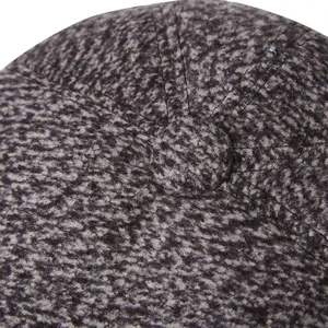 Close-up detail of grey tweed winter flat cap with wool blend texture and top button
