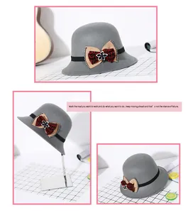 Detail van grijze wollen cloche hoed met strass bloem en decoratieve strik voor