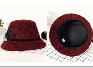 Detail view of red and black bucket hat with mesh bow, pompom and size label inside
