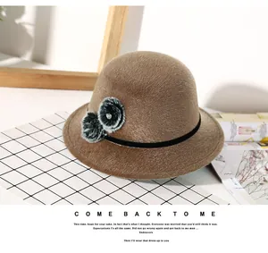 Detail of khaki cloche hat with textured faux fur flower decor and black ribbon