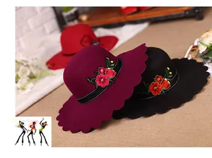Detail of elegant wool fedora hat with wavy brim and red floral embroidery in three colors