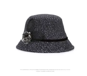 Detailed texture of dark grey wool blend bucket hat with black velvet ribbon and faux fur pom