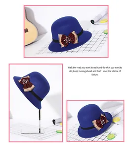 Detail van een blauwe wollen vilten cloche hoed met decoratieve strik en kralenaccenten